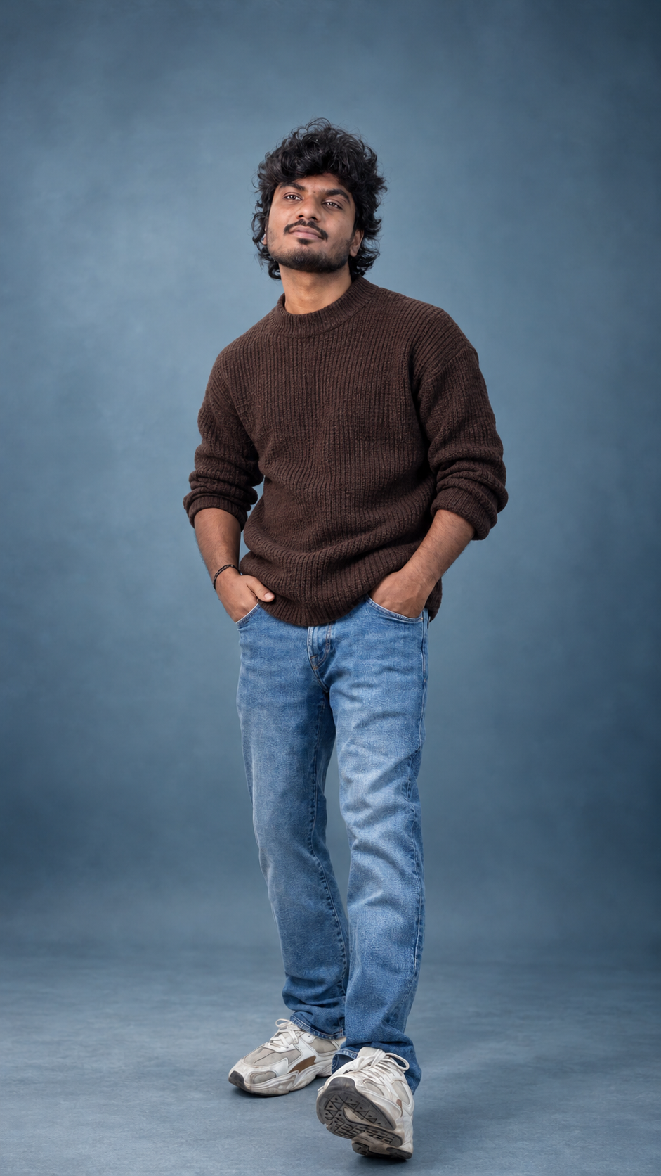 Full-length portrait walking toward the camera in a brown sweater and jeans