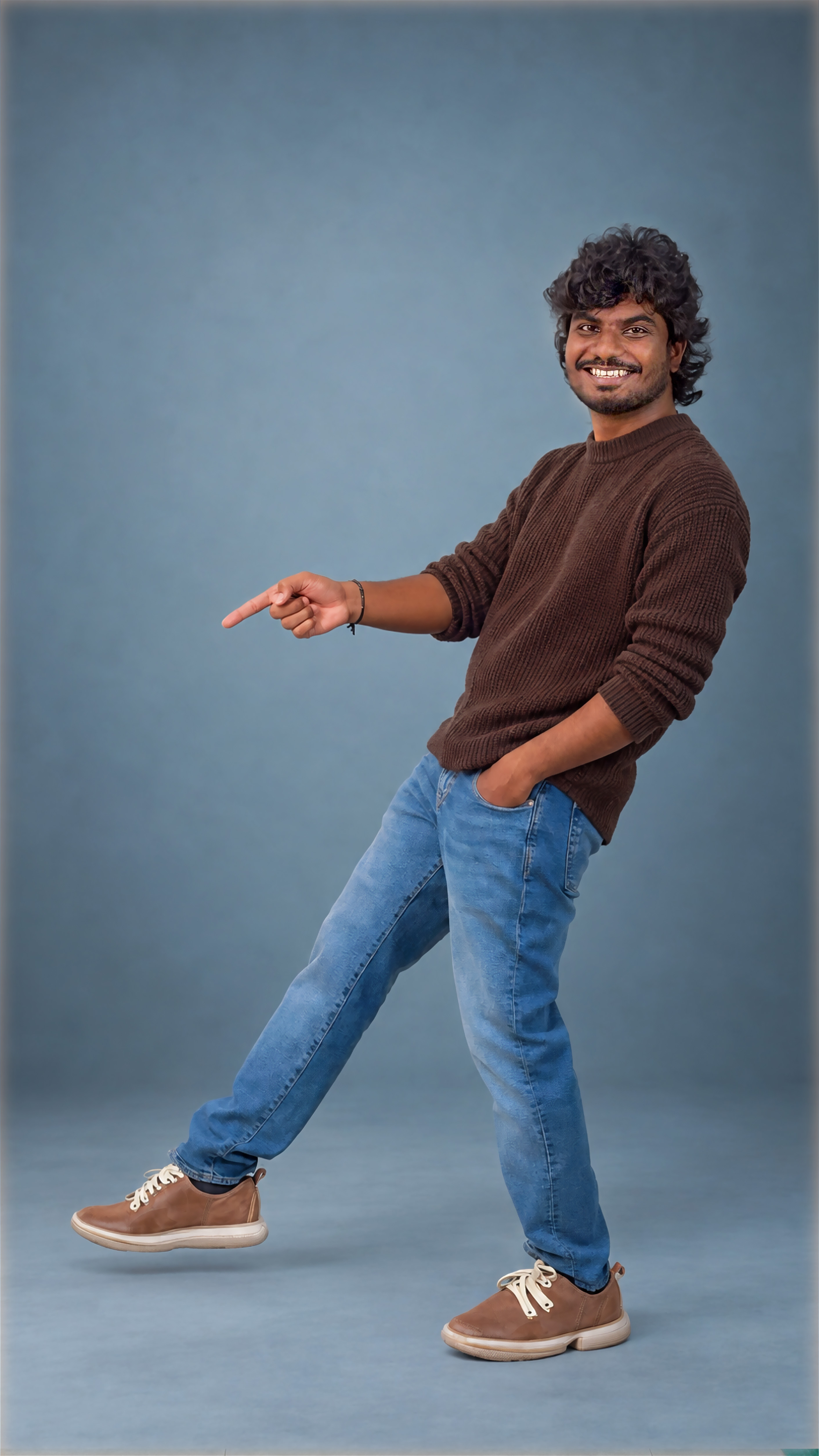 Full-length shot mid-step, grinning and pointing off frame